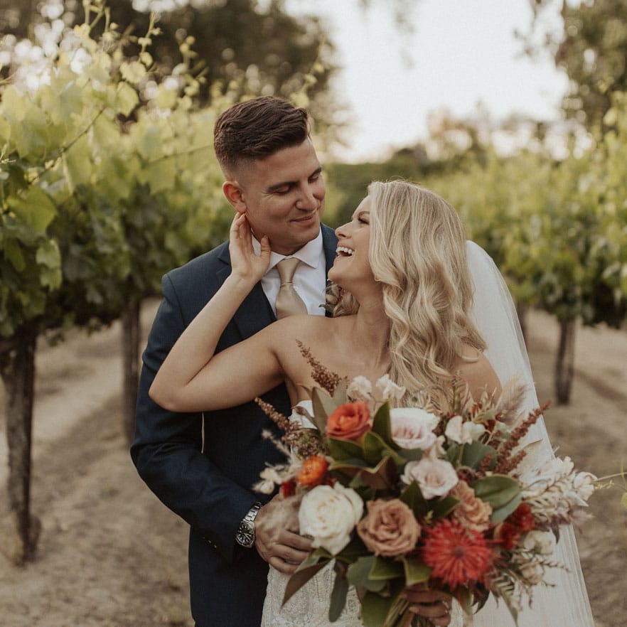 A bride & groom have a wedding photo session in the vines.