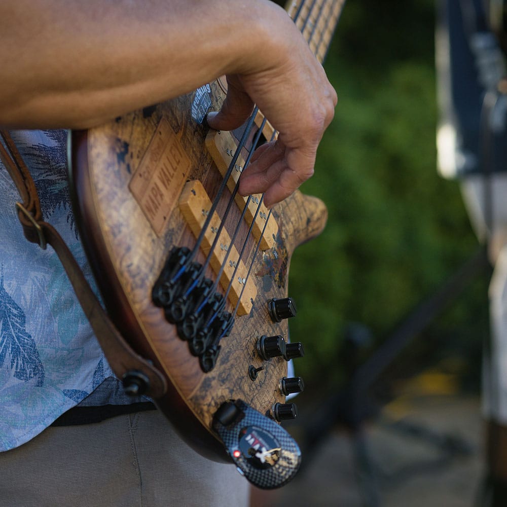 A close up of a guitar being played by a band member.