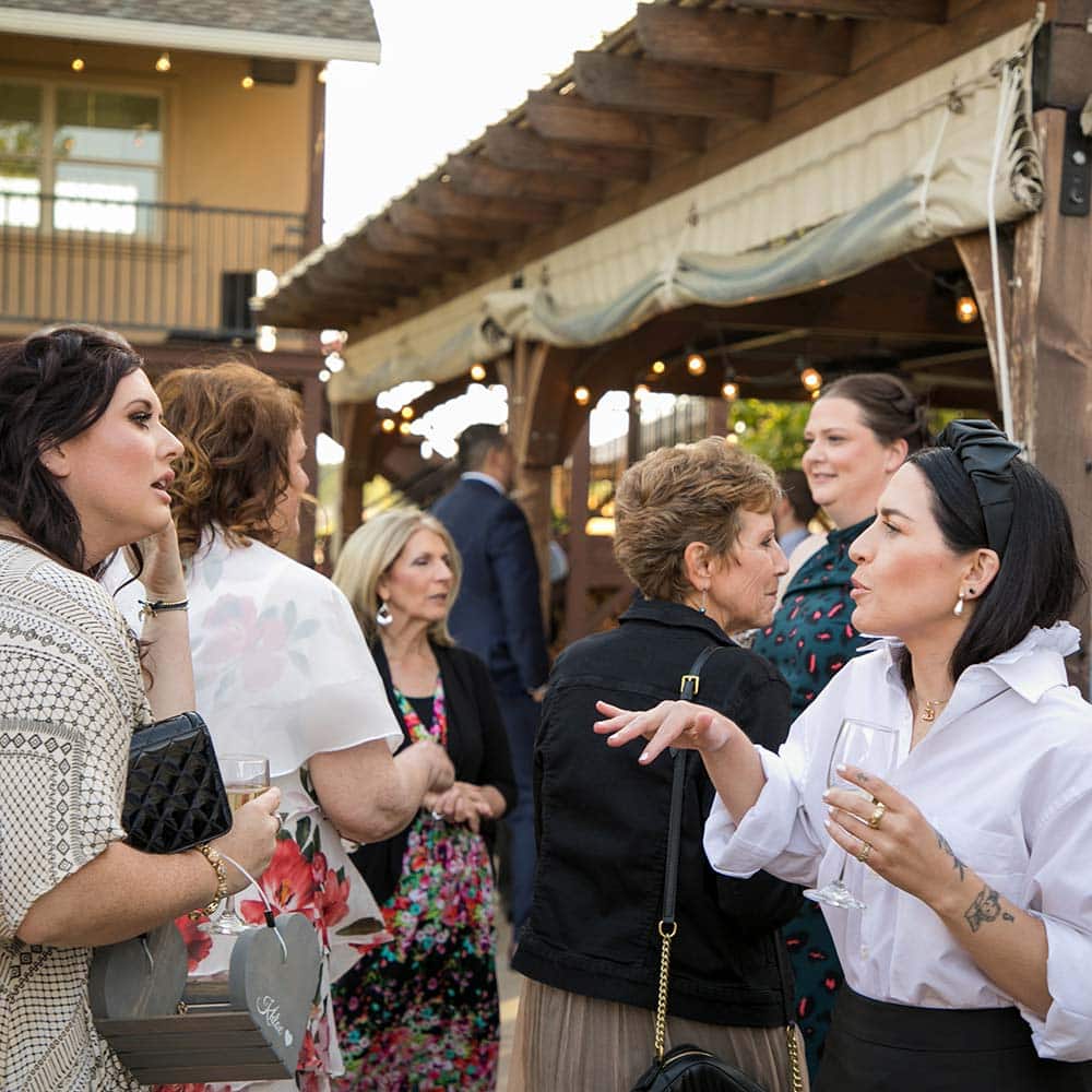 A handful of winery guests talk to each other during a reception.
