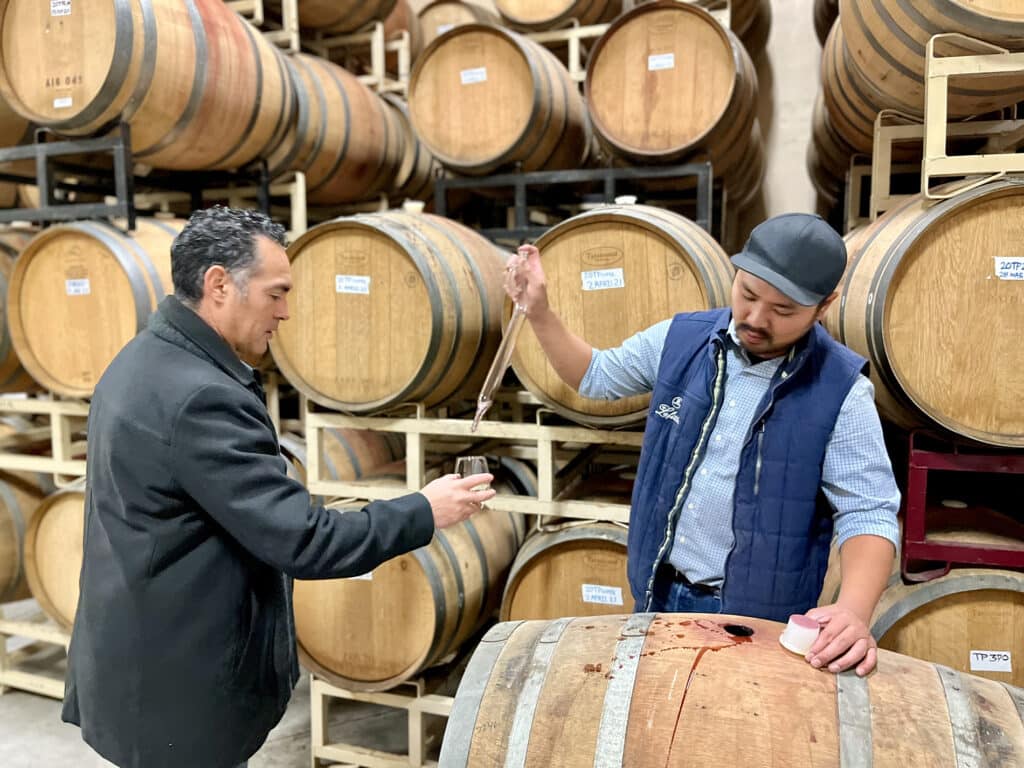 Winemaker gives barrel sample of Tempranillo to male guest at new winery event at Scribner Bend.
