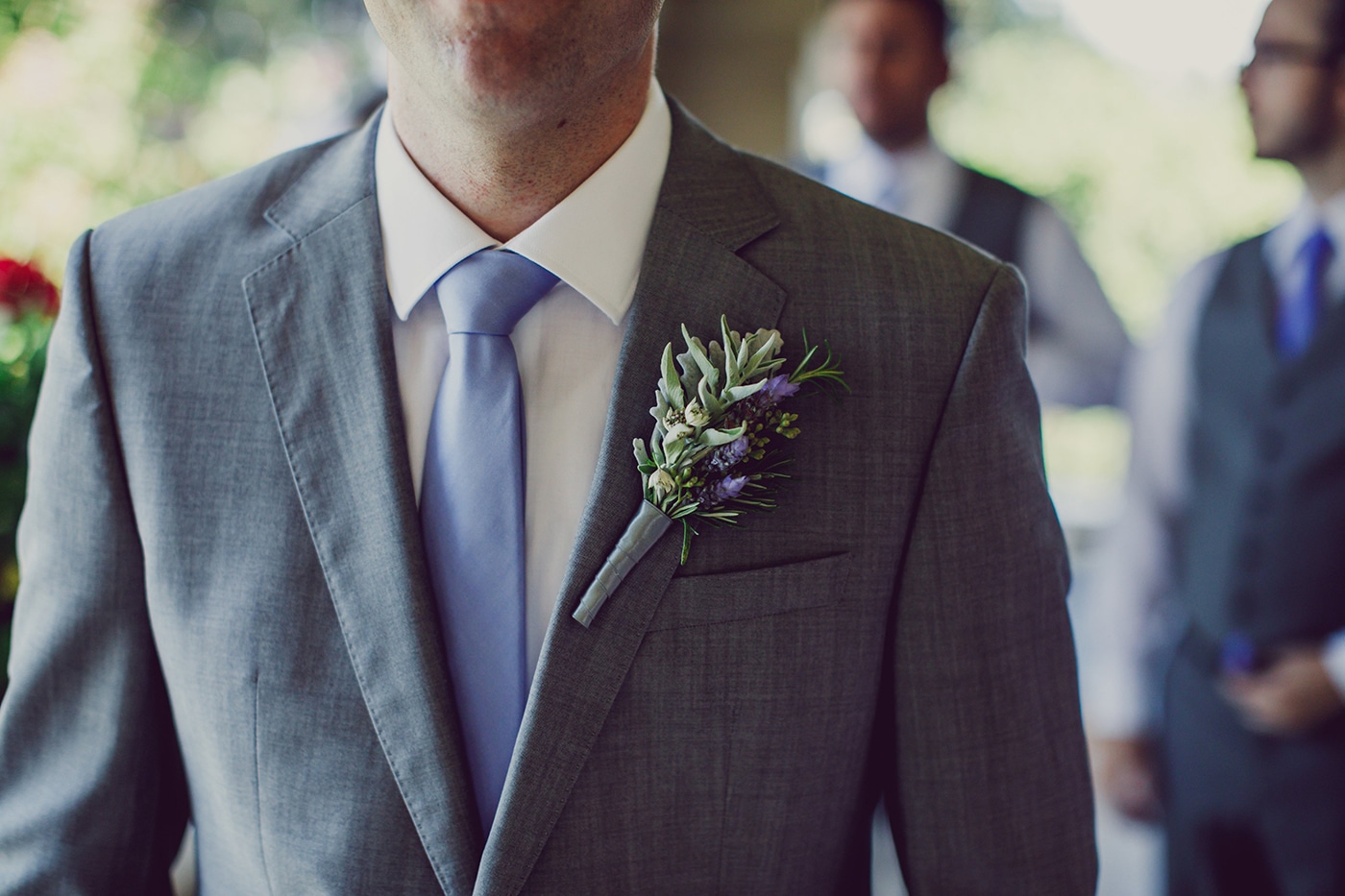 Close up of groom at Scribner Bend Vineyards wearing boutonniere with lavender and rosemary.