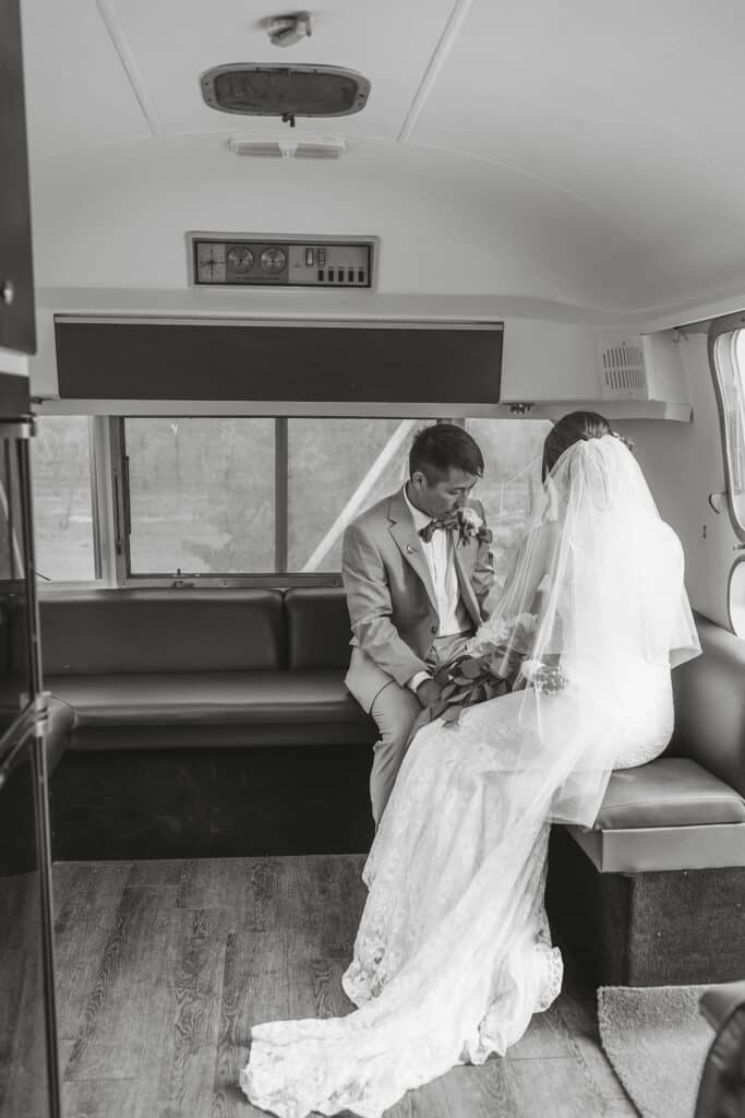 Bride and groom share a quiet moment alone in a remodeled Airstream after their ceremony.