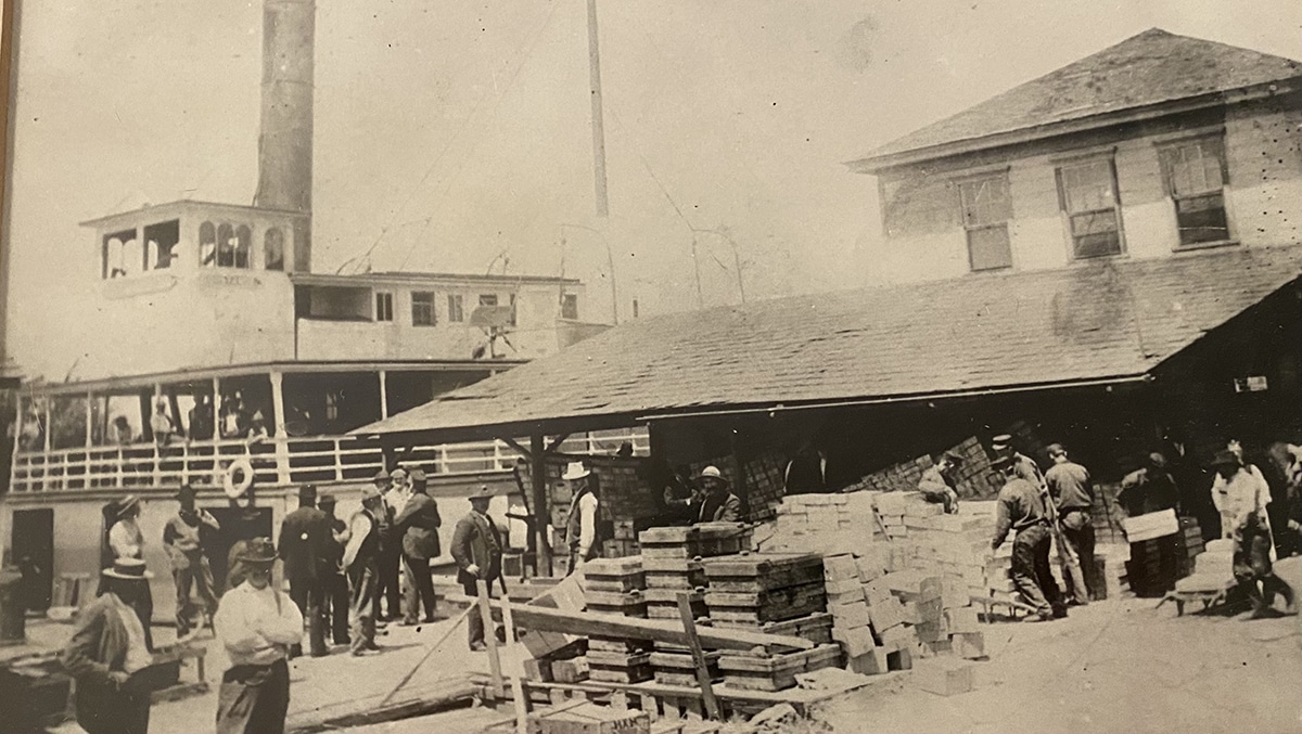 People unload produce from a Sacramento Delta steamboat at the Courtland dock in the early 1900s.